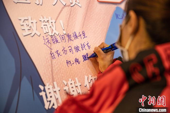 云南医疗队医护人员在感恩墙共同写下美好的祝福 王孙致远 摄